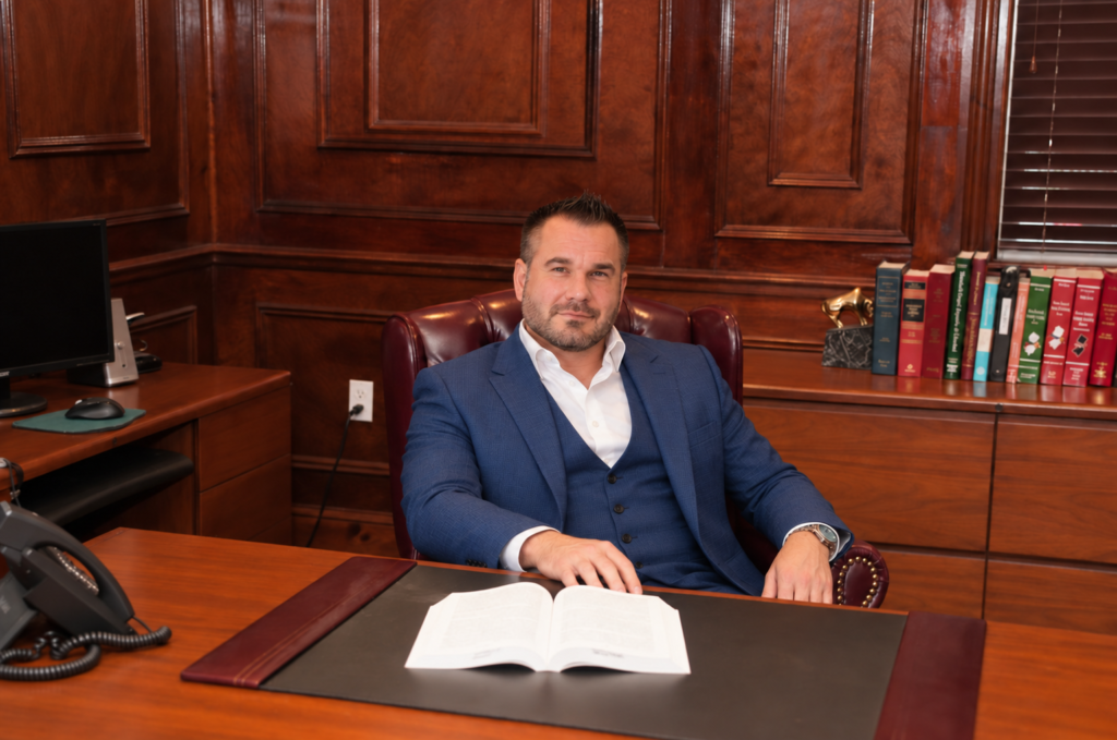 Brian Crockett seated at a desk in a wood-paneled office.